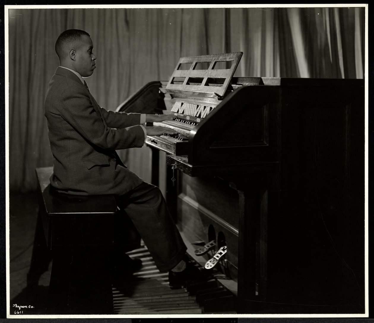 Afroamerikanischer Mann spielt Orgel in der New York Association for the Blind, 111 East 59th Street, New York, 1934 von Byron Company