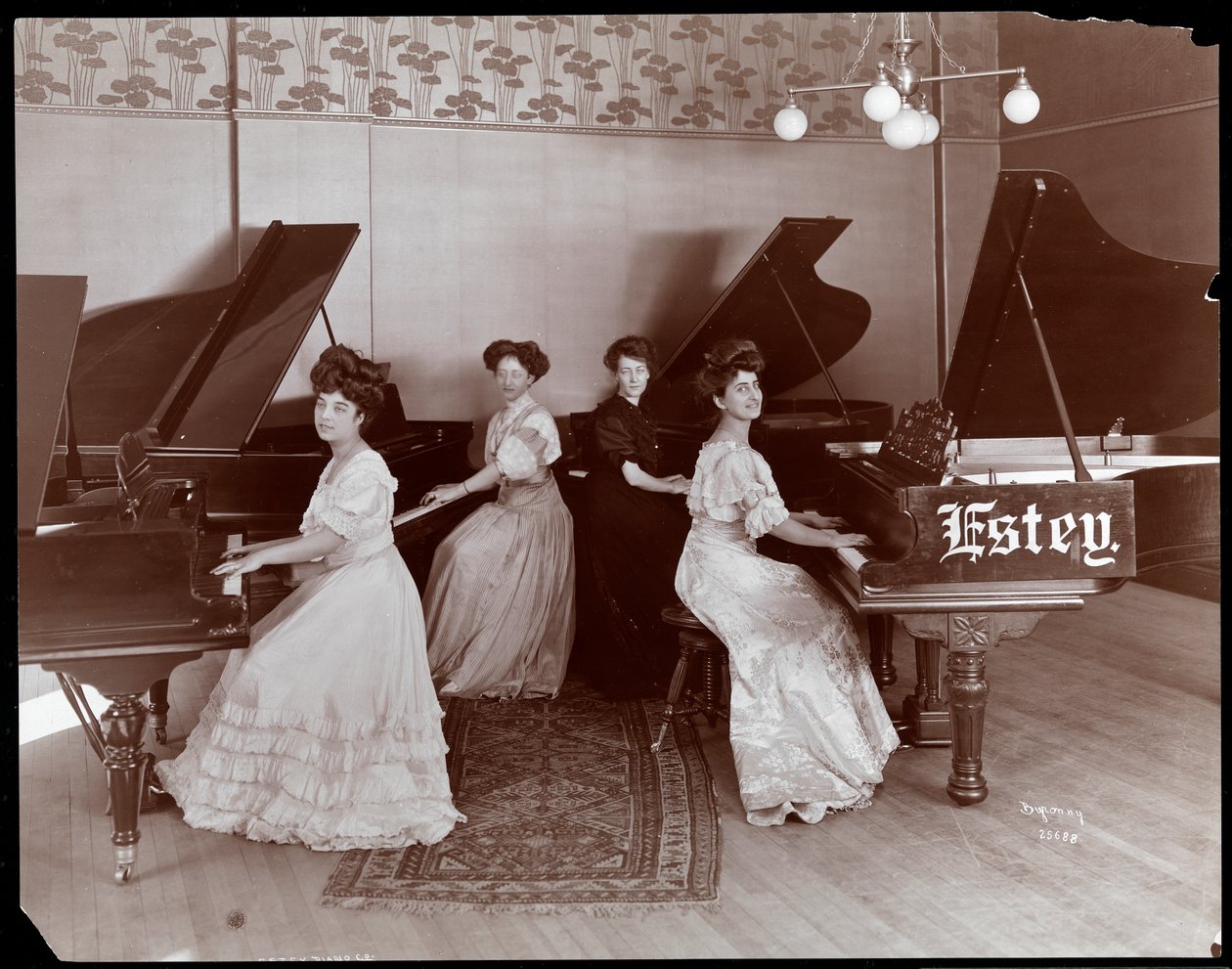 Vier Frauen sitzen an der Estey Piano Corporation, 1908 (Silbergelatine-Druck) von Byron Company