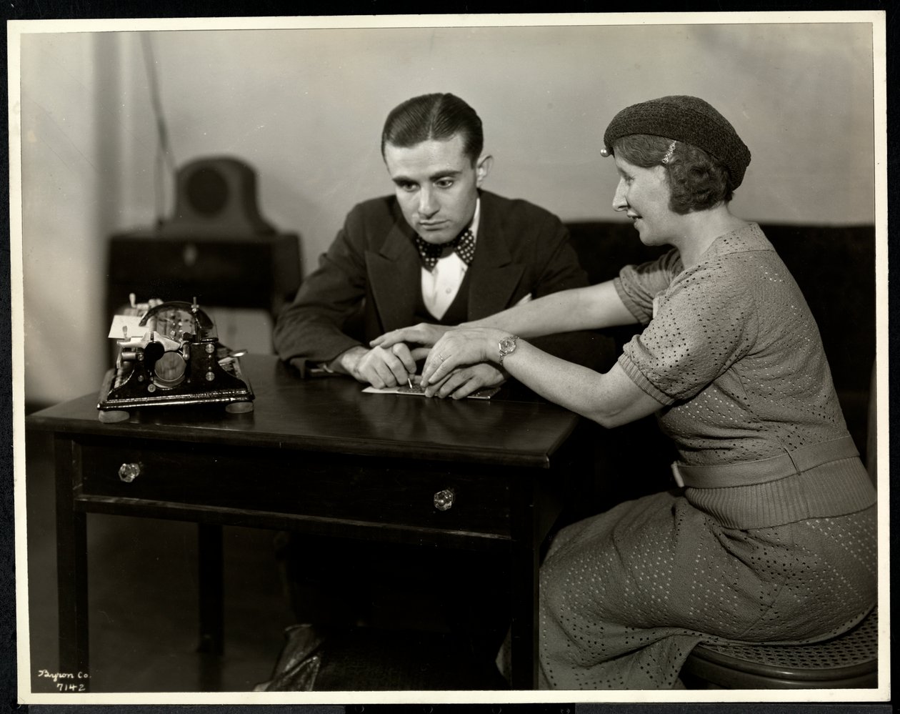 Frau bringt einem blinden Mann das Lesen in Braille bei, New York Association for the Blind, 111 East 59th Street, New York, 1935 von Byron Company