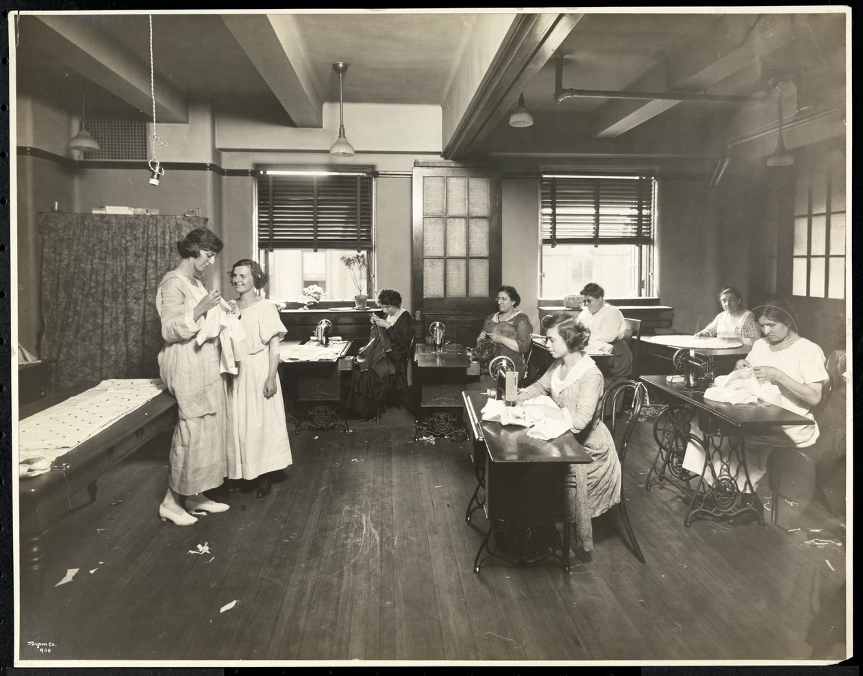 Blinde junge Frauen und eine Lehrerin beim Nähen in einem Klassenzimmer der New York Association for the Blind, 111 East 59th Street, New York, 1921 von Byron Company