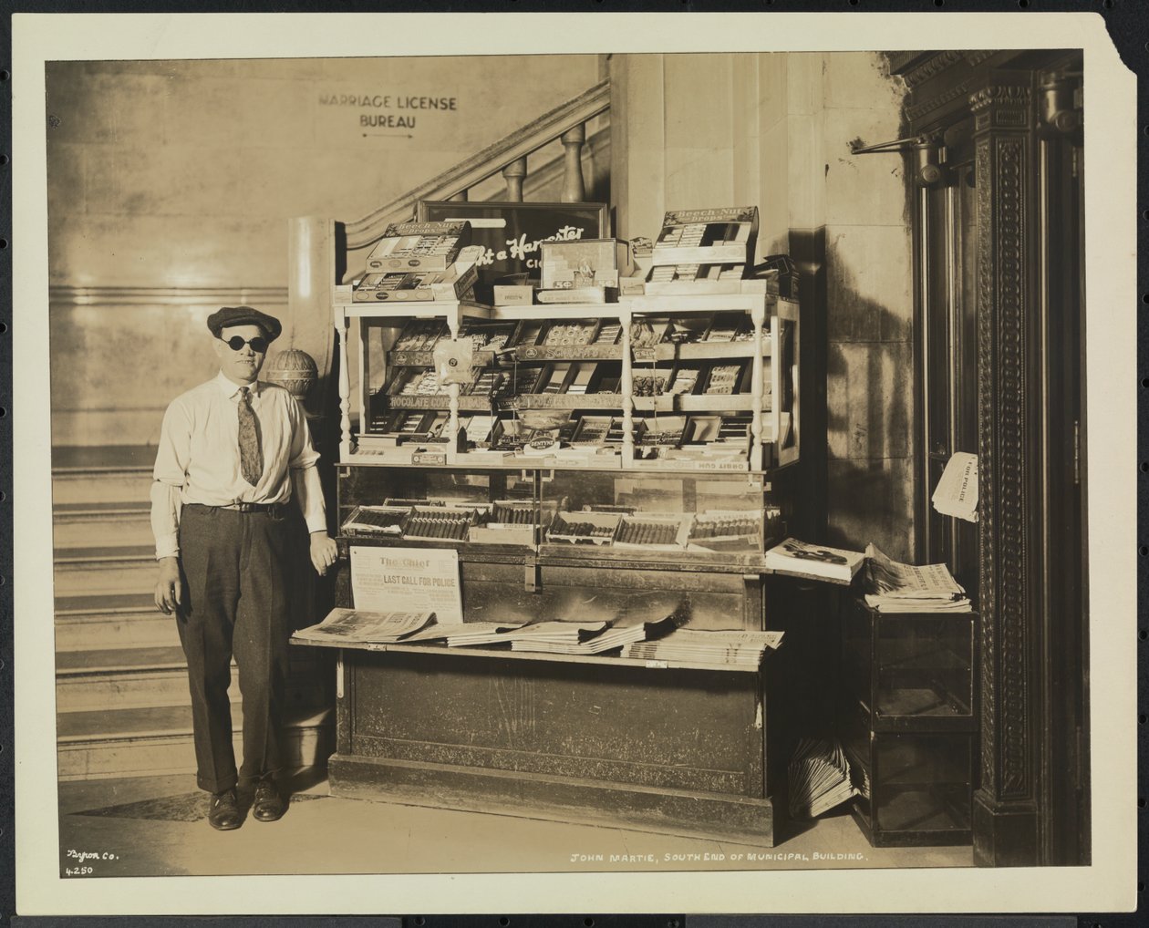 Blinder Zeitungsverkäufer, John Martie, an seinem Stand am südlichen Ende des Municipal Building, New York von Company Byron