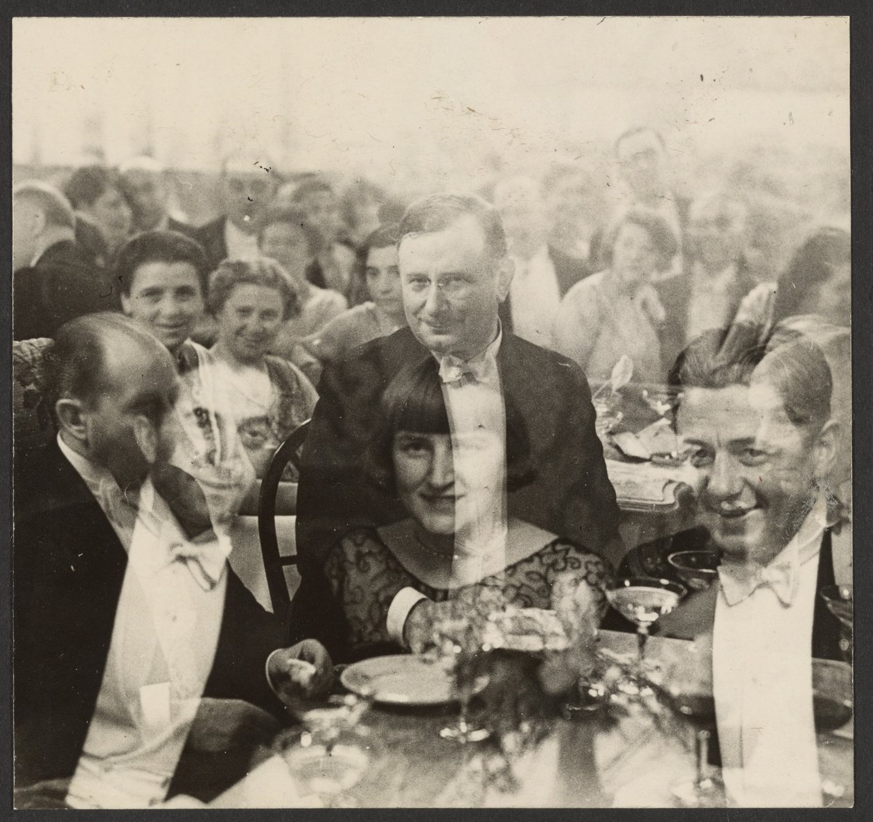 Doppelbelichtung einer Gruppe von Menschen bei einem Bankett von Erich Salomon