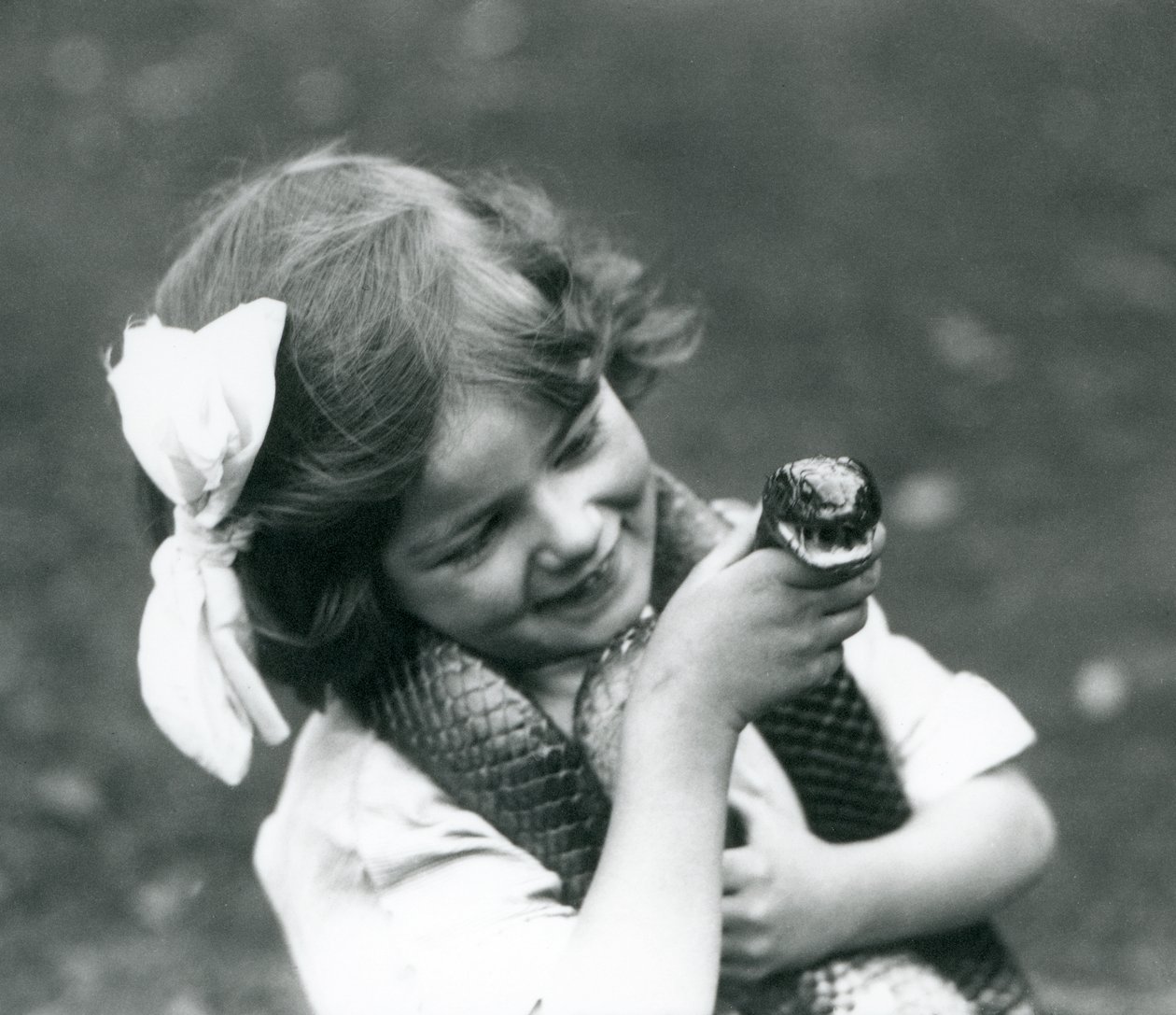 Ein junges Mädchen Betty hält eine östliche Indigo-Schlange, London Zoo, 1924 von Frederick William Bond