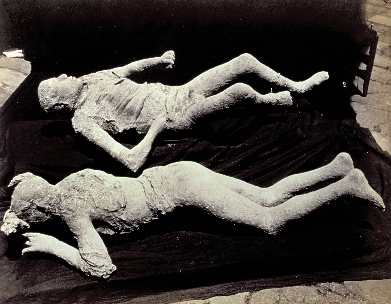 Zwei Abgüsse von menschlichen Figuren aus den Ausgrabungen von Pompeji. Die Exponate wurden auf schwarzem Tuch platziert, um sie zu fotografieren von Giorgio Sommer