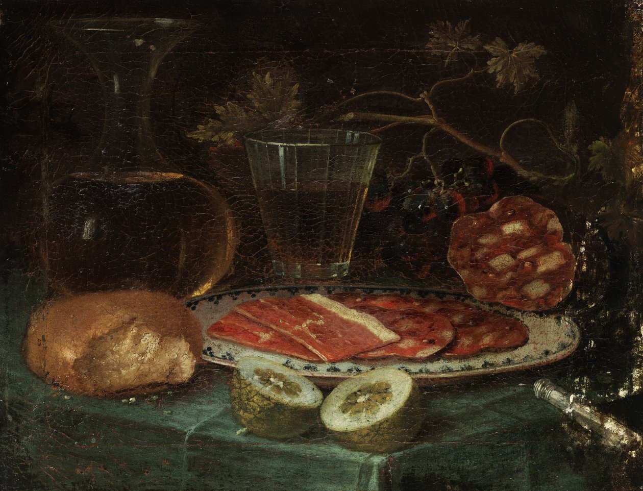 Stillleben mit Brotstück, Glaskaraffe, Weinglas, Platte mit Schinken und Schinkenwurst, Zitrone und Messer mit Perlmuttgriff von Italo-flämischer Maler des 17. Jahrhunderts