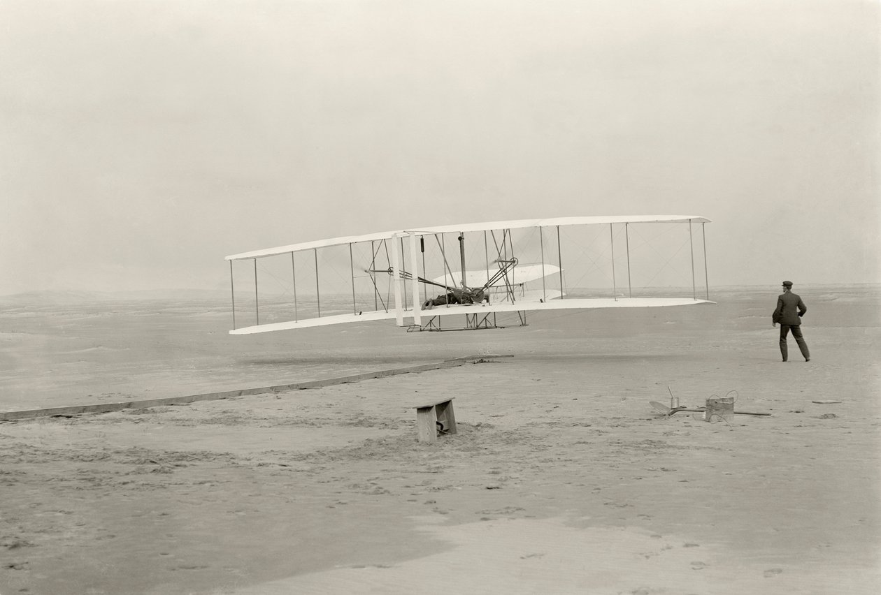 Der Wright Flyer I macht seinen ersten Flug von 120 Fuß in 12 Sekunden in Kitty Hawk, North Carolina von John T. Daniels