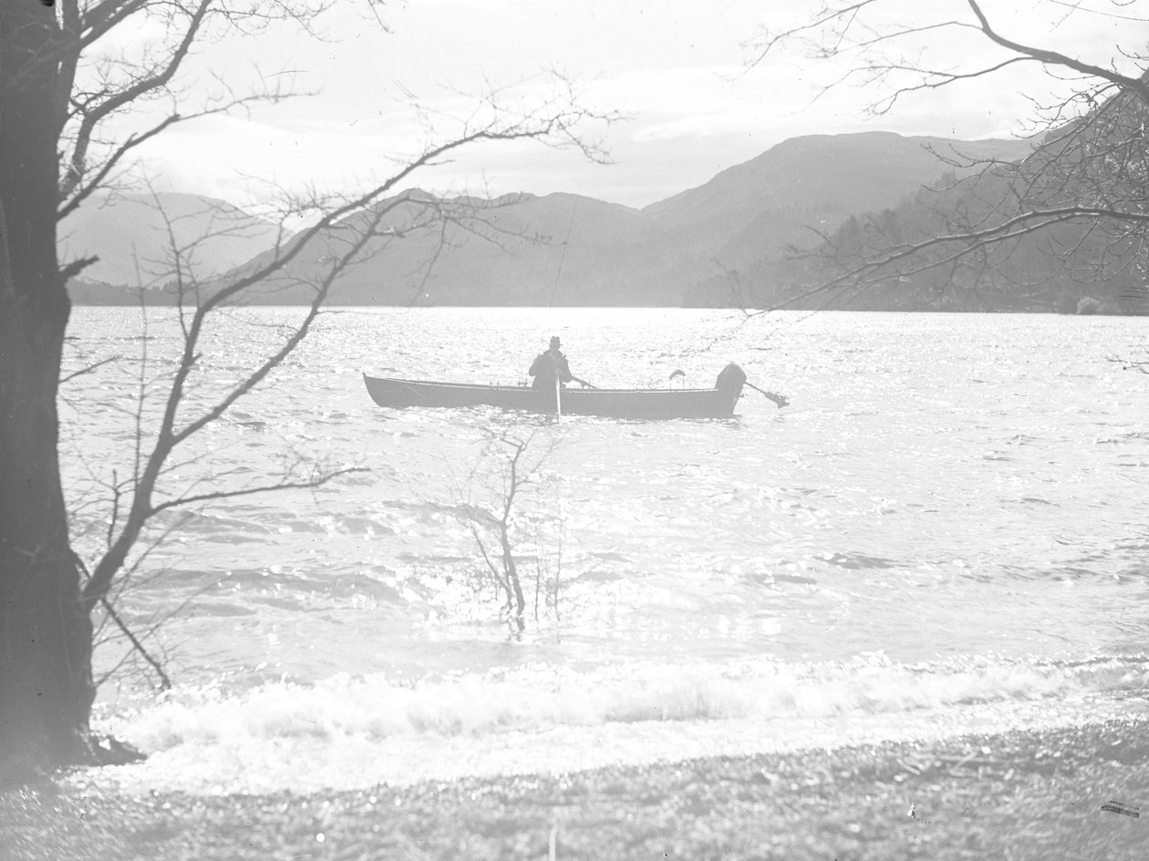 Ein Mann sitzt in einem Boot auf einem See und angelt, mit Hügeln im Hintergrund von Joseph Hardman