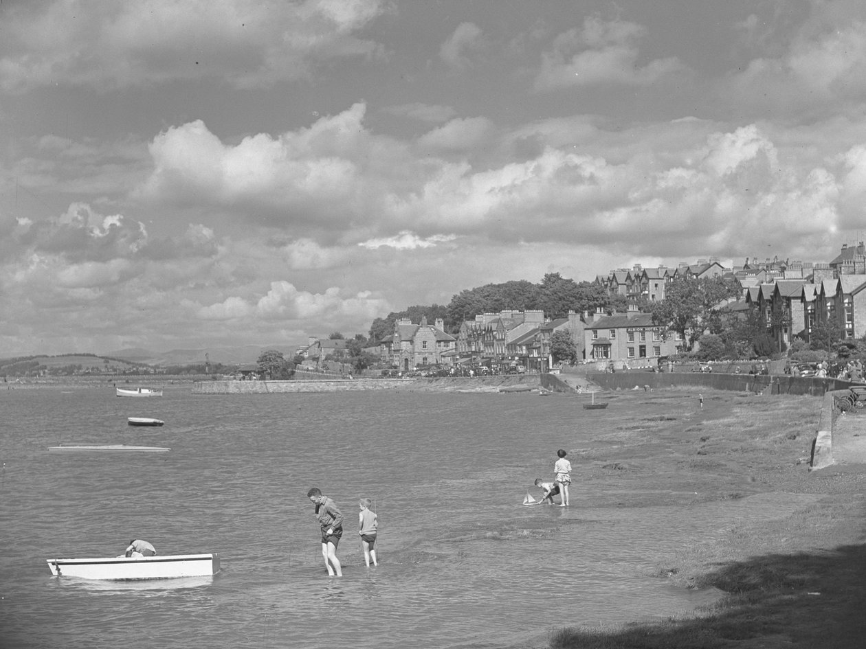 Menschen spielen in Booten bei Hochwasser in Arnside mit Albion Hotel im Hintergrund von Joseph Hardman