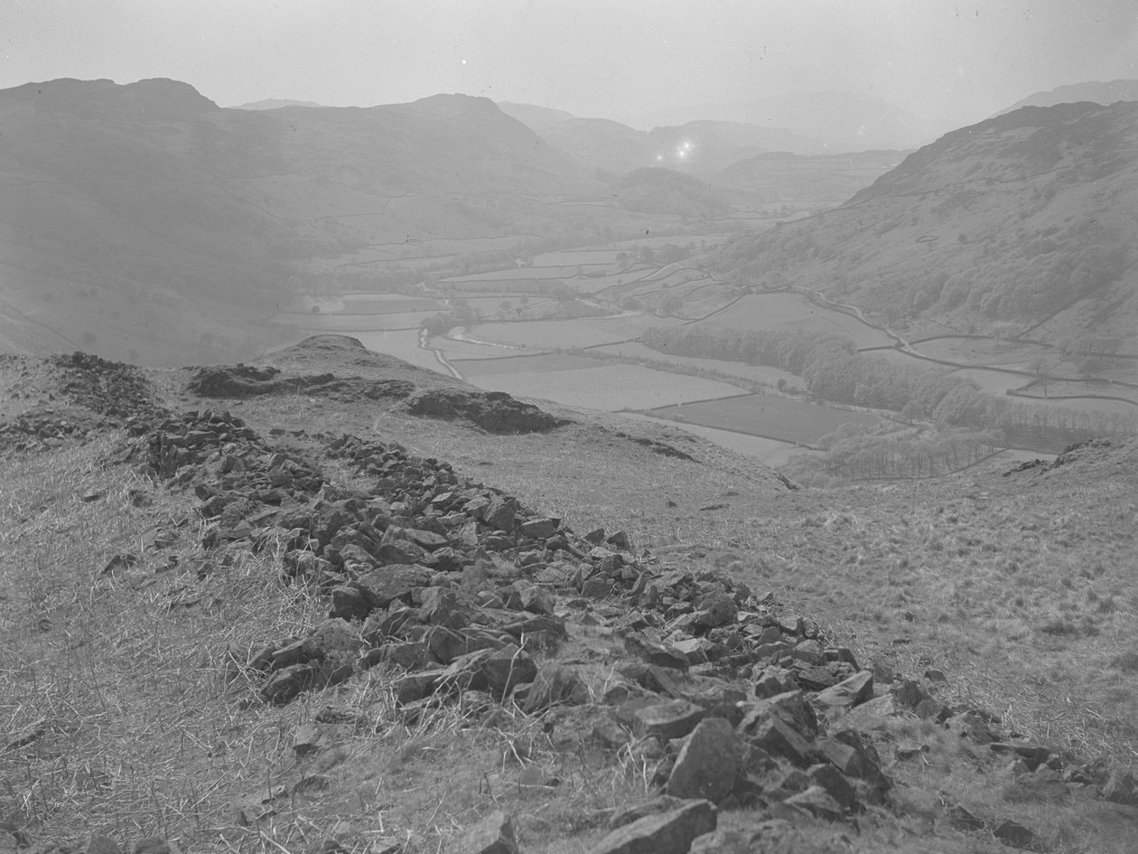 Blick über ein offenes Tal bei Hardknott mit Steinhaufen im Vordergrund von Joseph Hardman