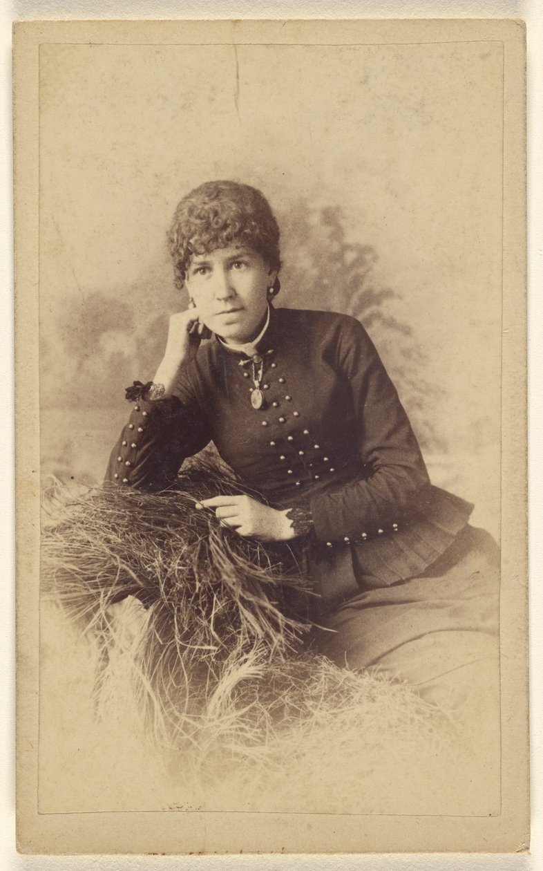 [Unidentifizierte Frau sitzt mit Hand auf der Wange, auf einem Heuhaufen posierend] von Miller and Company