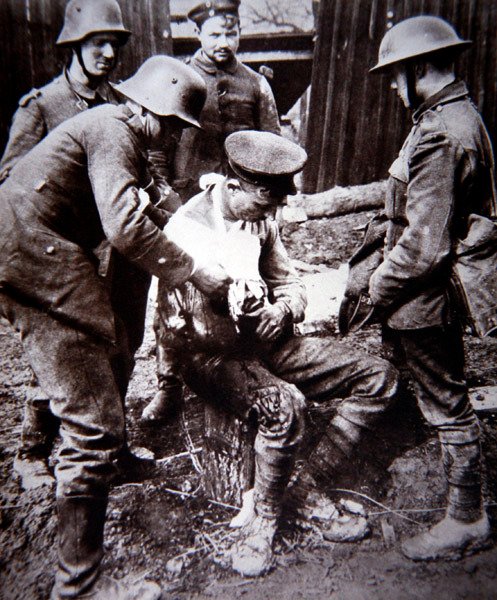 Erster Weltkrieg: Deutscher Sanitäter versorgt einen verwundeten britischen Soldaten an der Westfront von Photographer German