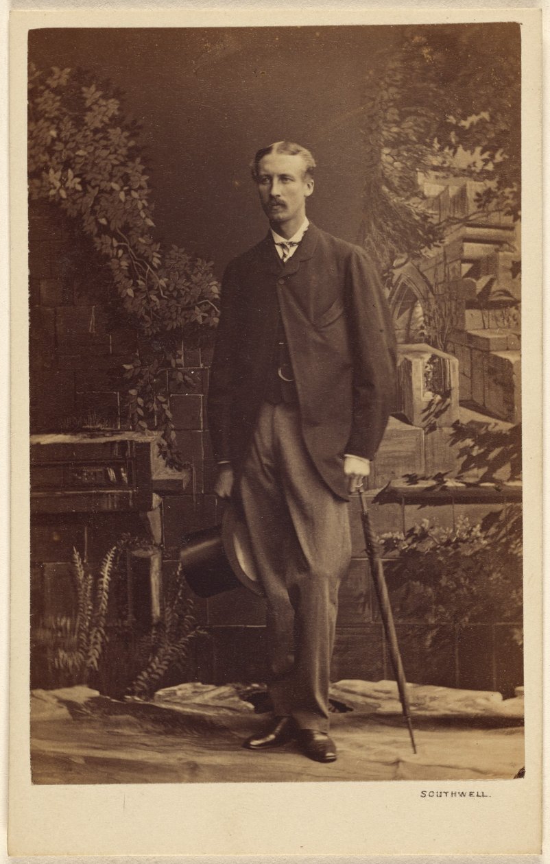 Unbekannter Mann mit Schnurrbart, der einen Zylinder und einen Regenschirm hält, stehend von Southwell Brothers