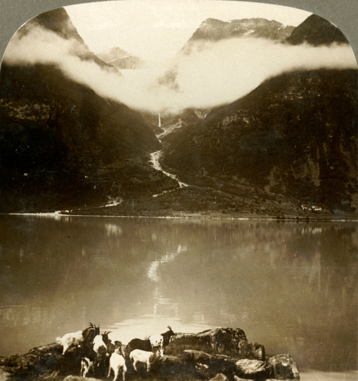 Grytereids-Gletscher, der über treibenden Wolken über dem ruhigen See Olden, Norwegen, glitzert von Unbekannt