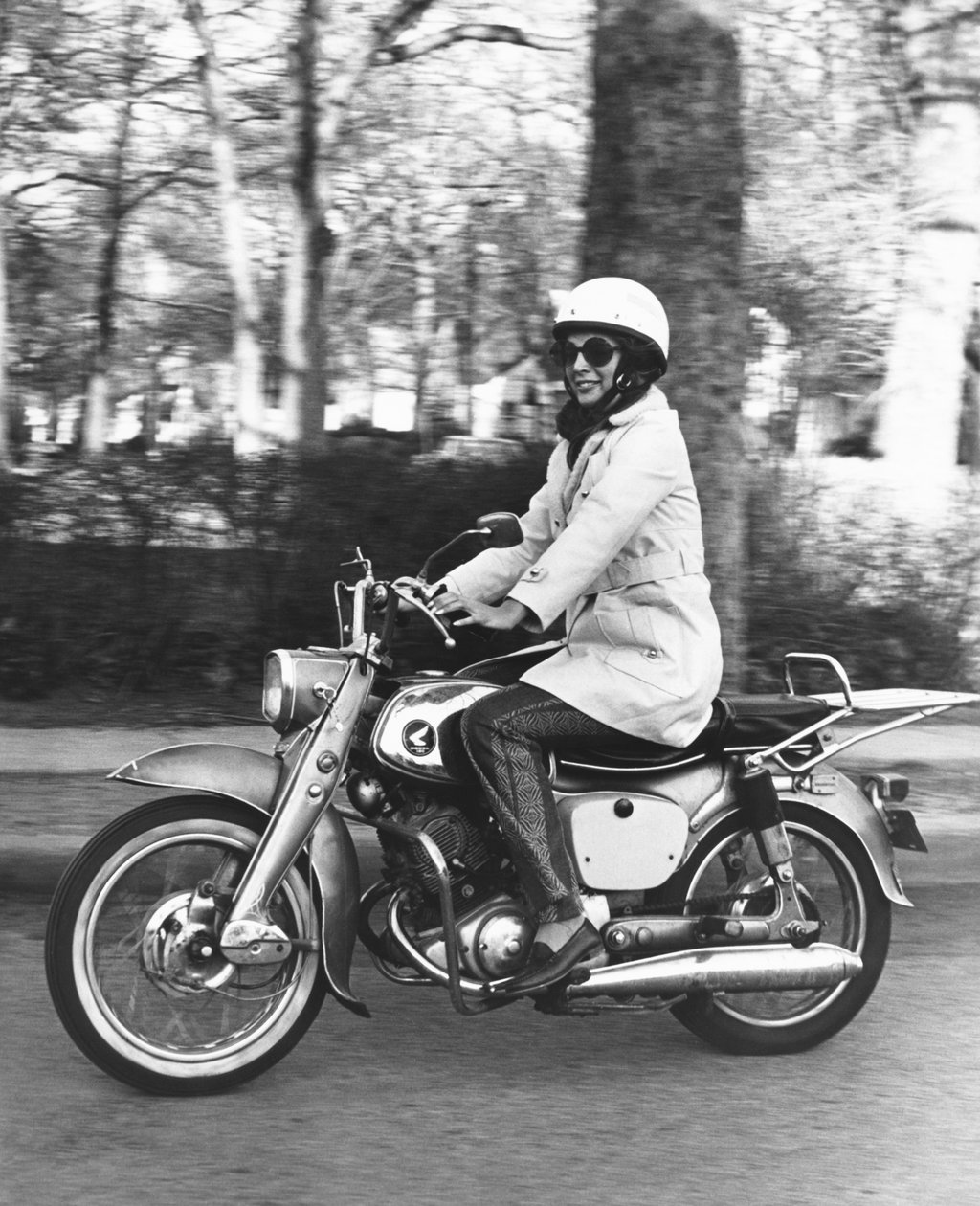 Vereinigte Staaten: ca. 1961 Eine Frau fährt auf ihrem Honda 160 Motorrad. (s/w Foto) von Unbekannt