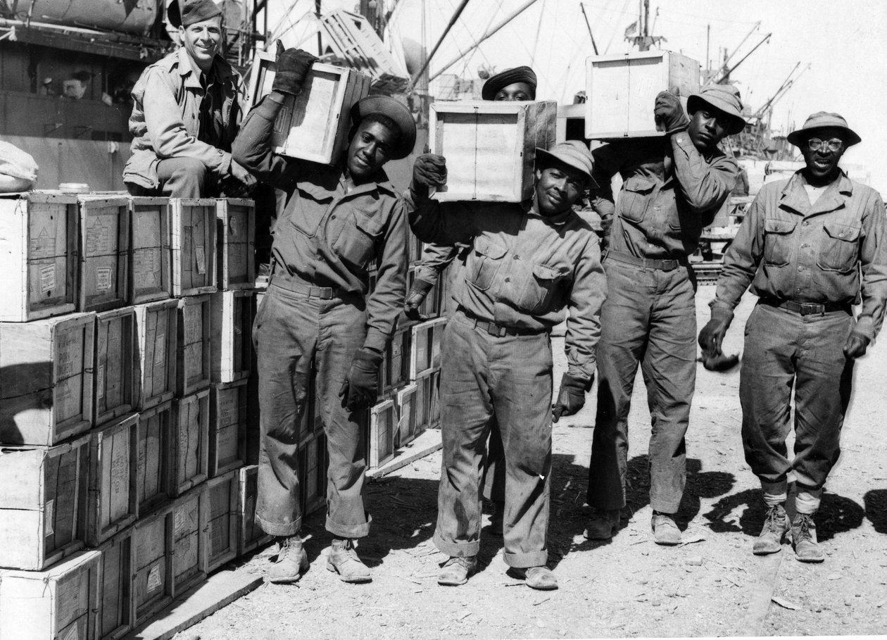 Zweiter Weltkrieg (1939-1945): Naher Osten April 1943: In einem Hafen entladen Mitglieder eines Hafenbataillons der US-Armee afroamerikanische Soldaten militärische Ausrüstung. von Unbekannt
