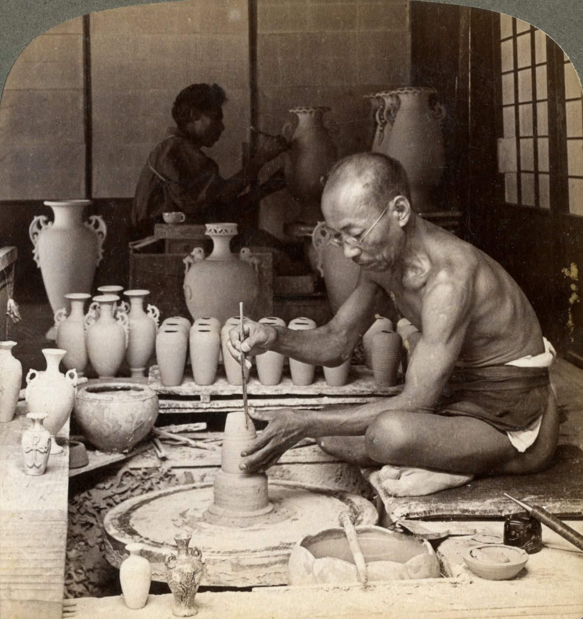 Ein Töpfer und sein Rad, formt eine Vase aus Awata-Porzellan, Kinkosan-Werke, Kyoto, Japan, 1904 von Underwood and Underwood
