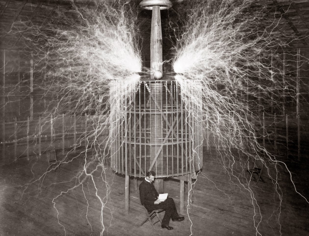 Nikola Tesla sitzt in seinem Labor in Colorado Springs mit seinem „Vergrößerungssender“ von Unknown photographer
