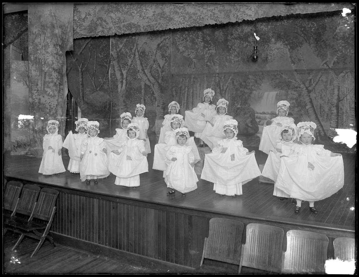 Kindergärtnerinnen auf der Bühne: sehr kleine Mädchen treten auf einer kleinen Bühne auf, wahrscheinlich das römisch-katholische Waisenhaus, Kingsbridge, Bronx, ca. 1911 von William Davis Hassler