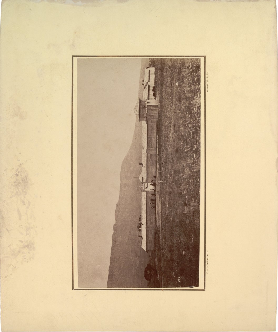 Ansicht eines Palisadenzauns mit mehreren Männern am Eingangstor, 1871 von William Hicks Jackson