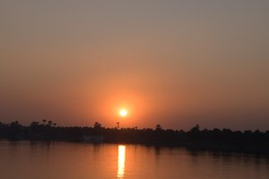 Goldene Sonnenuntergangsreflexionen auf einem ruhigen Fluss von Albert Mansour