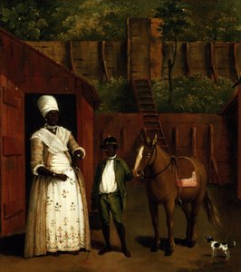 Eine schwarze Mutter und Sohn mit einem Pony vor einem Stall