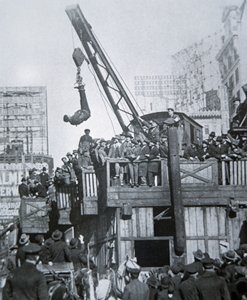 Houdini entkommt aus einer Zwangsjacke, während er an einem Kran in New York City hängt von American Photographer