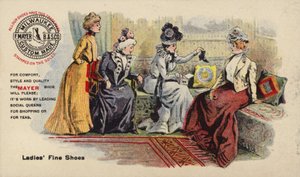 Damen sitzen auf Sofa und bewundern Stiefel von American School