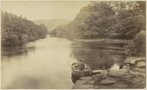 Flusslandschaft in England, mit einem Mann im Ruderboot im Vordergrund