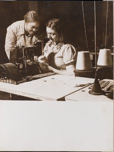 Zwei Frauen benutzen eine Nähmaschine von Arnold Eagle