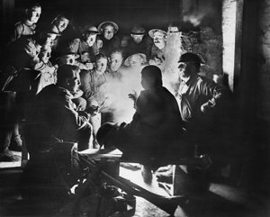 Mitglieder der 1. Australischen Leichten Mörserbatterie, 1. Australische Division, hören die neuesten Nachrichten von einem ihrer Kameraden um ein Feuer in einer Unterstand-Unterkunft in Ypres, 28. Oktober 1917
