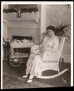 Mrs. Howard sitzt mit einem Buch in einem Schaukelstuhl in ihrem Haus in der 5th Avenue 200, New York, 1915-6