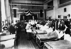 Dekorierter Salon in einem Krankenhaus mit Kriegsverwundeten während eines priesterlichen Besuchs (s/w Foto) von Carlo Wulz