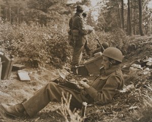 Kriegsberichterstatter Alan Wood tippt eine Depesche von D.M. Sgt. Smith