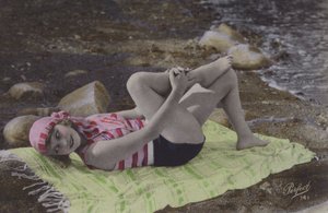 Mädchen liegt auf Handtuch am Strand von English Photographer