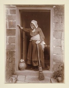 Eine alte Dame mit einer Hefeflasche an einer Hüttentür