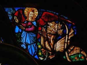 Das Westrosenfenster zeigt eine Szene aus dem Buch der Offenbarung: Drache verfolgt die Mutter des Knaben; aber sie hat Flügel, um in die Wüste zu fliegen (12:13-14).