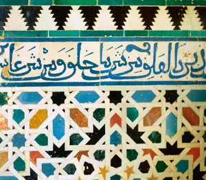 Ring mit Inschrift in blauen Kacheln auf weißem Hintergrund, der Sätze aus dem Koran wiedergibt