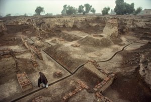 Übersicht über eine Grube, die mit den Überresten von Ziegelmauern und einem Ziegelbrunnen gefüllt ist. HARAPPA E...