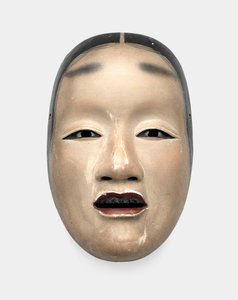Eine Holzmaske mit Gofun-Grundierung, bemalt mit Sumi für Haare, Augen und Zähne und Rot für die Lippen