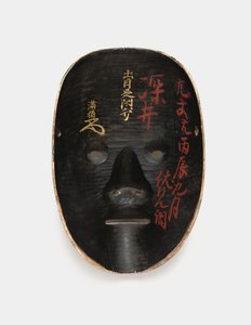 Rückseite einer Holzmaske mit Sumi bedeckt, lackiert mit roten Inschriften