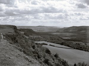 Eine Dame steht auf einem Hügel und blickt über die Landschaft bei Scout Scar
