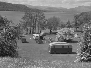 Zelte und Wohnwagen auf einem Feld bei Wastwater, See und Hügel im Hintergrund