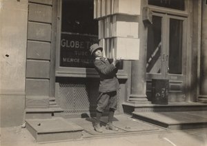 Wagenjunge oder "Schwanzjunge" hilft beim Beladen des Wagens, ca. 1914