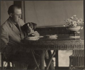 Mann und Hund am Tisch sitzend