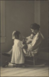 Mutter im Schaukelstuhl mit Kindern von Louis Fleckenstein