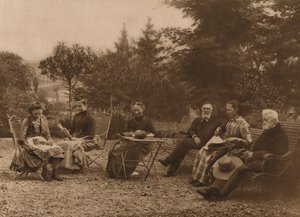 Eine Gruppe von Männern und Frauen sitzt an einem Tisch und unterhält sich