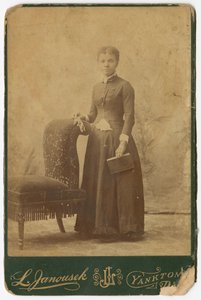 Fotografie einer Frau, die neben einem Stuhl steht und ein Buch hält, spätes 19. Jahrhundert von Louis Janousek