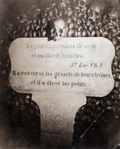 Die Beinhäuser der Katakomben von Paris. Peter trägt ein Zitat aus Kapitel 1 des Evangeliums von Lukas (Deposuit potentes de sede et exaltavit humiles. Auf Französisch: Er stürzte die Großen und erhob die Kleinen)