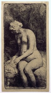 Eine Frau badet ihre Füße an einem Bach