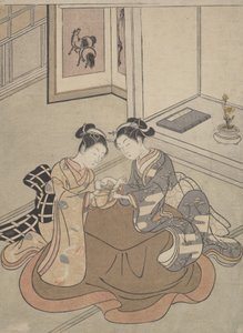 Zwei junge Frauen, die an einem Kotatsu sitzen und Fadenspiele spielen, ca. 1765 von Suzuki Harunobu